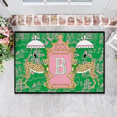 a door mat with the letter b and two cheetah in front of it