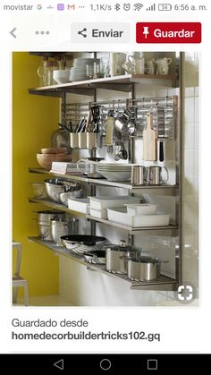 a metal shelf filled with lots of pots and pans next to a yellow wall