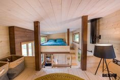 there is a loft bed in the middle of this room with wood flooring and walls