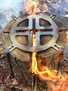 a metal cross sitting on top of a fire pit