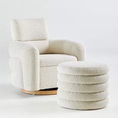 a white chair and ottoman sitting next to each other on a white surface with a wooden base