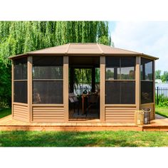 a gazebo sitting on top of a wooden deck in the middle of a park