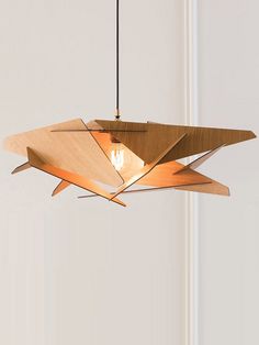 a wooden light fixture hanging from a ceiling in a room with white walls and doors