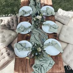 the table is set with plates and napkins on it, along with other place settings