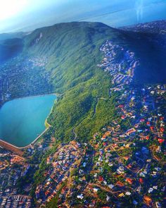 an aerial view of a small town on the side of a mountain with a lake