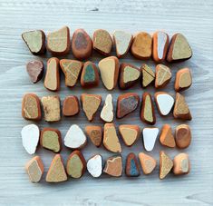 several different types of rocks laid out on a wooden surface with white and brown colors