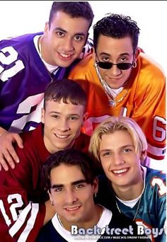 four young men are posing together for a photo in front of an american football uniform