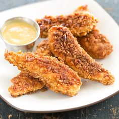 fried chicken sticks with dipping sauce on a white plate