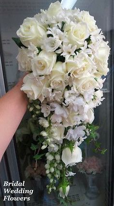 a bouquet of white flowers is being held up