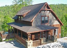 an aerial view of a house with mountains in the back ground and trees on either side