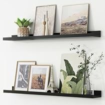 two black shelves with pictures and plants on them