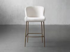 a white bar stool in front of a gray wall