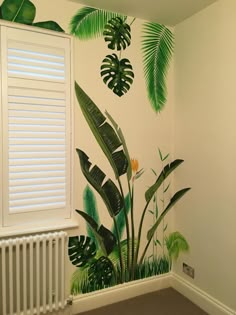 a room with palm leaves painted on the wall and a radiator next to it