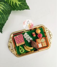 a small tray with food on it next to a green plant and leafy leaves