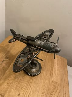 an old model airplane sitting on top of a wooden table