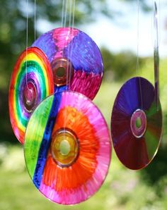 three colorful discs hanging from strings outside