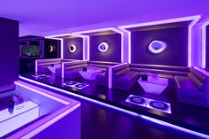 the interior of a modern restaurant with purple lighting