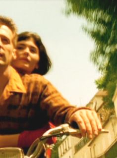 a man riding on the back of a motorcycle next to a women's head