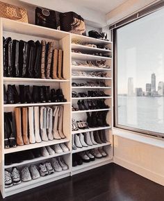 a closet with many pairs of shoes on shelves next to a window overlooking the water