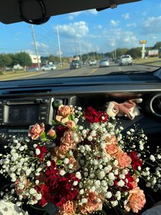 a bouquet of flowers is sitting in the passenger seat of a car on the road