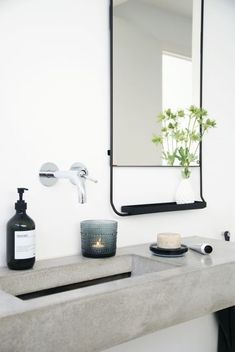 a bathroom with a sink, mirror and soap dispenser on the counter