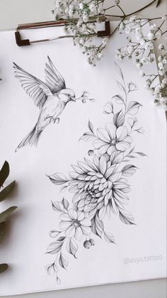 a drawing of two hummingbirds flying over flowers on a sheet of paper with scissors next to it