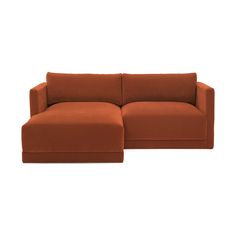 an orange sectional sofa sitting on top of a white floor next to a brown ottoman