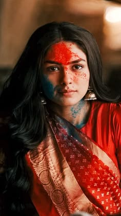 a woman with red and blue paint on her face