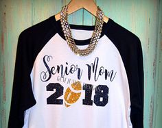 a white and black baseball shirt with the words senior mom in 2013 printed on it