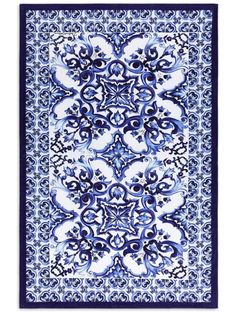 a blue and white rug with an ornate design on the bottom, in front of a white background