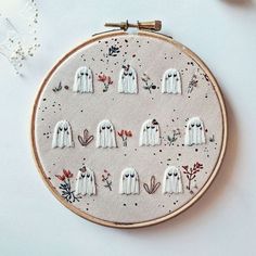 a cross stitch pattern with white ghost faces on it