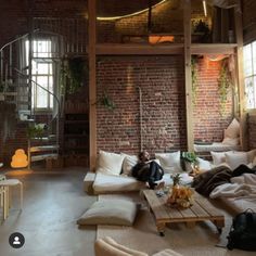 a living room filled with lots of furniture next to a spiral stair case on the wall