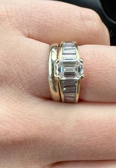 a close up of a person's hand wearing a ring with two stones on it