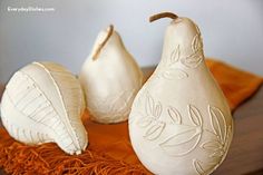 three ceramic pears sitting on top of a wooden table