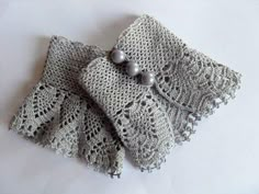 two pieces of crocheted cloth with pearls on them