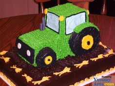 a green tractor cake sitting on top of a wooden table