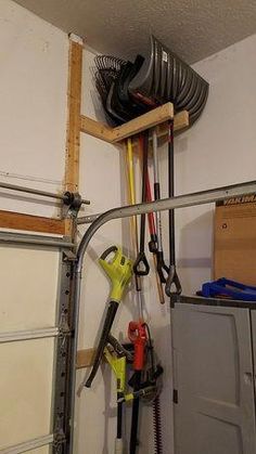 there are many different tools hanging on the wall in this garage with no one around