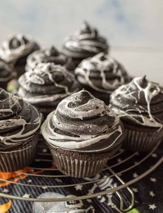 chocolate cupcakes with white frosting on a cooling rack