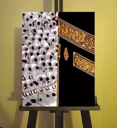 an open book with white and black designs on it sitting on top of a wooden easel