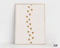 a white card with gold foil hearts hanging from it's sides on a shelf