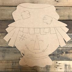 a paper cut out of a child's face on top of wood planks