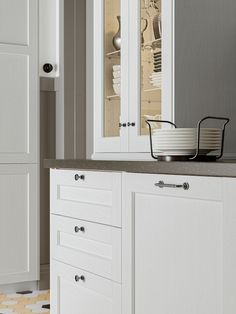 a kitchen with white cabinets and gray counter tops is seen in this image from the front