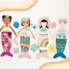 three mermaid dolls are standing next to each other on a white background with colorful waves