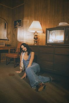 a woman sitting on the floor in front of a tv