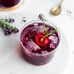 a glass filled with liquid and garnished with a piece of fruit on top