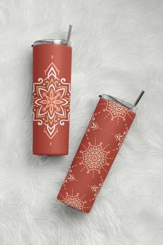 two red and gold tumblers sitting on top of a white fur covered floor next to each other