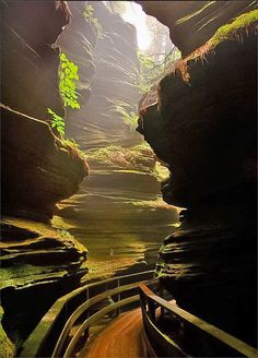 the sun shines through an opening in a rock formation with water flowing from it