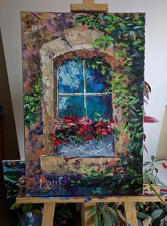 an easel with a painting on it that has flowers growing out of the window