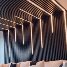 a living room filled with white couches and black striped wall behind it's windows