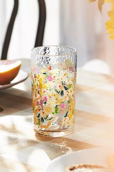 a glass filled with water sitting on top of a table next to a slice of fruit